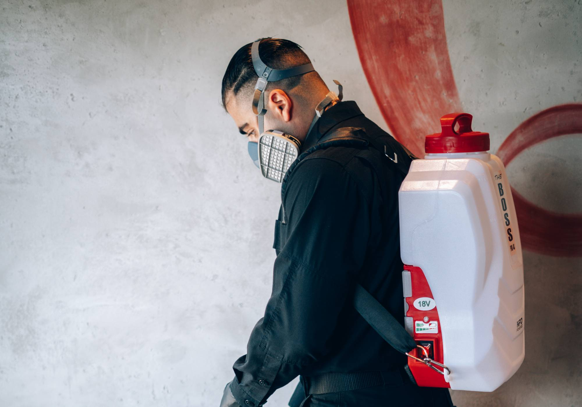 Phantom Pest Control technician wearing a respirator and a battery-powered backpack sprayer